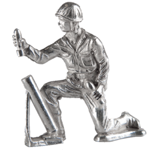 Silver metallic sculpture of a kneeling worker holding a cylindrical object.