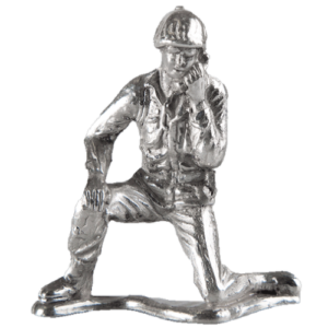 A metallic figurine of a kneeling soldier in military attire.